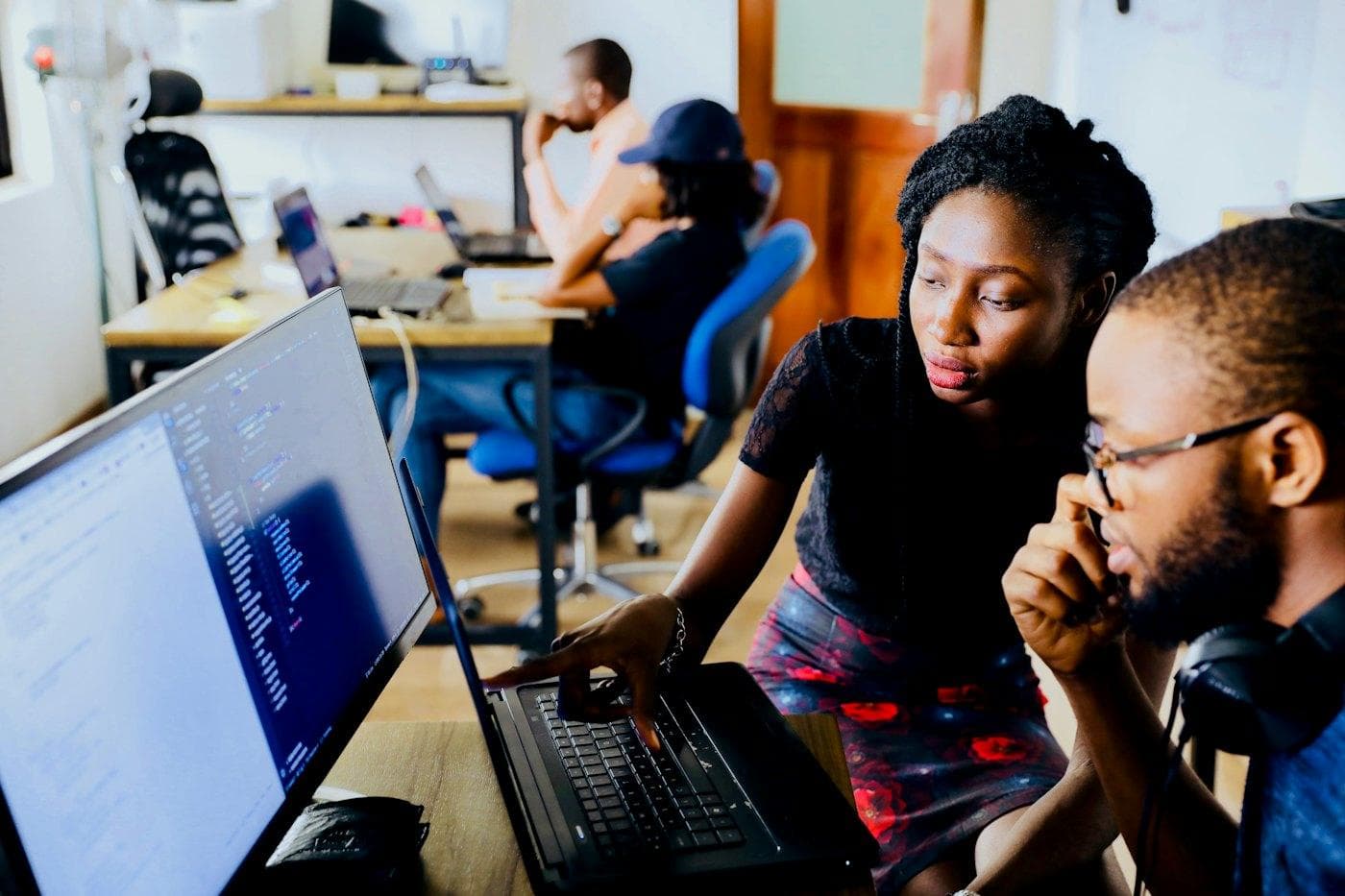 A small team looking at a laptop screen together